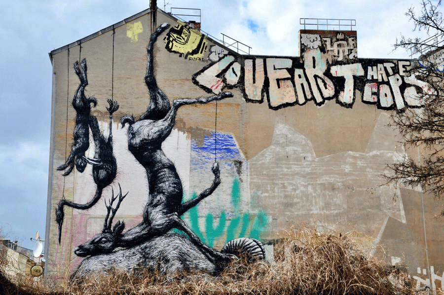 Eine Fotografie einer Hauswand. Auf der Wand sind vom Dach hängende tote Tiere zu erkennen. Fotograf: Holger Kistenmacher