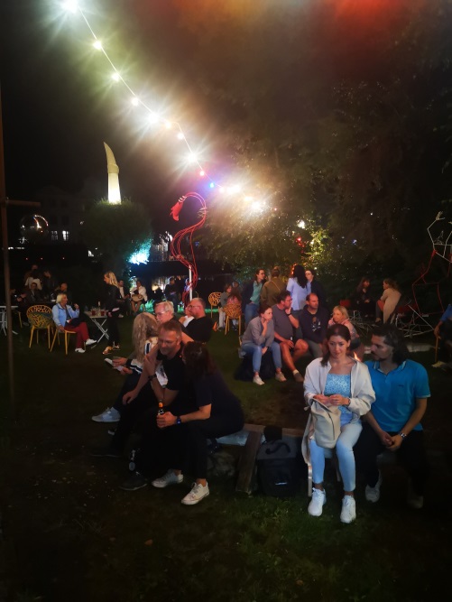 unscharfe Fotografie einer Party im Garten der Kunsttankstelle mit buntem Licht und vielen jungen Menschen